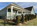 A delightful covered porch and a row of evergreen trees line the back of this charming home at 1113 Hudson Dr, Mebane, NC 27302