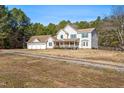 Charming two-story home featuring a spacious front porch and a detached three-car garage with ample parking at 1175 Faulkner Town Rd, Henderson, NC 27537