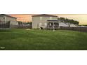 Spacious backyard with a wooden fence, covered porch, and plenty of room for outdoor activities at 128 Glacier Pt, Clayton, NC 27527