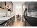 Galley kitchen with stainless steel refrigerator, sink, and views of the dining area at 1287 Schaub Dr # J, Raleigh, NC 27606