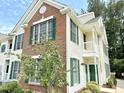 Exterior view of a condo featuring brick and siding, green shutters, and a small balcony at 1522 Kudrow Ln, Morrisville, NC 27560
