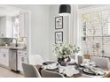 Dining area with seating for six, modern lighting, and view into the updated kitchen at 2204 Guess Rd, Durham, NC 27705