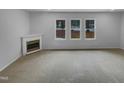Cozy living room featuring large windows and a fireplace at 3300 Mossdale Ave, Durham, NC 27707