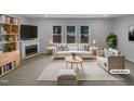 Bright living room with large windows, a fireplace, and stylish, comfortable furniture. (Virtually Staged) at 3300 Mossdale Ave, Durham, NC 27707