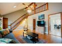 Bright living room featuring a staircase, hardwood floors, a ceiling fan, and an open layout at 3320 Derbyshire Pl, Raleigh, NC 27604