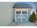 View of attached garage with carriage door design, showing detail and matching exterior paint at 416 Granite Saddle Dr, Rolesville, NC 27571
