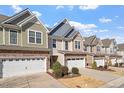 Charming townhomes featuring stone accents, siding, and attached garages in a well-maintained community at 468 Talons Rest Way, Cary, NC 27513