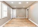 Bright, empty room with wood floors, fresh paint, and natural light streaming through the windows at 4704 Upchurch Ln, Wake Forest, NC 27587