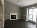 Bright living room with a fireplace, vaulted ceiling, and large windows for natural light at 500 Woodcroft Pkwy # 16D, Durham, NC 27713