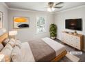 Bright bedroom featuring neutral walls, ceiling fan, bed, and natural light from the window at 5614 Greenbay Dr, Durham, NC 27712