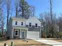Charming two-story home with gray and white siding, a two-car garage, and a well-manicured front lawn at 704 Mirror Pond Dr, Zebulon, NC 27597