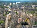 An aerial view of the home nestled amongst trees and a golf course with lake views at 103 Bruce Dr, Cary, NC 27511