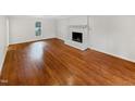 A spacious room with beautiful hardwood floors and a classic brick fireplace at 11308 Leesville Rd, Raleigh, NC 27613