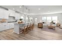 Open kitchen with white cabinets, oversized island, stainless appliances, and hardwood floors at 126 Belmont Stakes Ln, Wendell, NC 27591