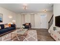 Inviting living room with a stylish blue sofa, patterned rug, and elegant decor at 155 Jade St, Smithfield, NC 27577