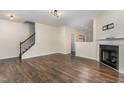 Spacious living room featuring hardwood floors, a staircase, and a cozy fireplace at 155 Jade St, Smithfield, NC 27577
