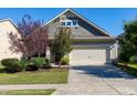 Charming home exterior with a well-manicured lawn, mature trees, and a two-car garage with a concrete driveway at 1707 Capstone Dr, Durham, NC 27713