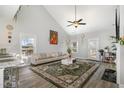Bright living room featuring a vaulted ceiling, ceiling fan, large rug, and comfortable seating at 192 Kensington Dr, Spring Lake, NC 28390
