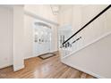 Bright foyer with hardwood floors, white wainscoting, and a staircase with dark banister at 203 Preston Oaks Ln, Cary, NC 27513