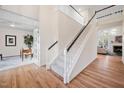 Bright foyer featuring hardwood floors and a staircase with carpet runner and black banister at 203 Preston Oaks Ln, Cary, NC 27513