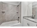 Modern bathroom with shower-tub combo, decorative tile, granite counter and modern fixtures at 208 Brickwell Way, Youngsville, NC 27596