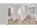 Bright hallway features wood-look floors, doorways to the bathroom, bedroom, and sliding glass door at 208 Brickwell Way, Youngsville, NC 27596