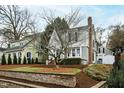 View of a charming two-story home featuring mature trees, manicured landscaping, and a classic architectural style at 2147 Wake Dr, Raleigh, NC 27608