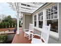 Inviting covered front porch showcasing white rocking chairs, brick flooring, and architectural details, perfect for relaxing at 2147 Wake Dr, Raleigh, NC 27608