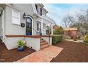 Charming front porch features brick steps, covered area, and beautiful landscaping, enhancing the home's curb appeal at 2147 Wake Dr, Raleigh, NC 27608