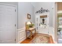Inviting foyer with natural light, featuring an accent table, hardwood floors, and elegant decor at 221 Elverson Pl, Cary, NC 27519