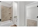 Neutral bathroom showcasing a shower-tub combo with decorative tile surround and a vanity with granite countertop at 305 Brickwell Way, Youngsville, NC 27596