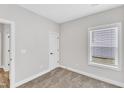 Cozy bedroom with neutral carpeting, a window providing natural light, and fresh white trim at 305 Brickwell Way, Youngsville, NC 27596