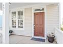 Inviting front entrance with a classic brown door, white trim, and a charming welcome mat at 4511 All Points View Way, Raleigh, NC 27614