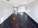 Spacious living room featuring dark hardwood floors, ample natural light and neutral walls at 6025 Herston Rd, Raleigh, NC 27610