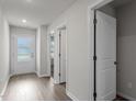 Bright hallway featuring wood-look flooring, white walls, and doors leading to various rooms at 605 Benton Dr, Oxford, NC 27565