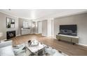 Spacious living room with fireplace, modern decor, light gray colored walls and wood-look floors at 621 Bashford Rd, Raleigh, NC 27606
