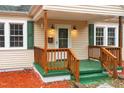 A close-up of the quaint front porch with its green floor and wooden railing at 673 Beck Ave, Henderson, NC 27536