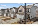 Row of cozy homes featuring two-car garages, gray siding, and well-manicured lawns at 729 Colby Pl, Durham, NC 27713