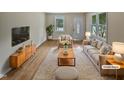 Bright living room featuring neutral decor, hardwood floors, and large windows with outdoor views at 802 Powell Dr, Garner, NC 27529
