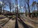 Beautiful exterior view of a brick home with a long driveway leading to a lakeside retreat at 8701 Oneal Rd, Raleigh, NC 27613
