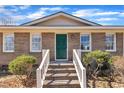 Welcoming front entrance featuring a brick facade, complemented by a vibrant green door and white trim at 98 S Denise Ave, Coats, NC 27521