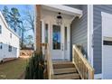 Close-up of the front door with glass panels, wooden steps, and gray siding at 1219 Chaney Rd, Raleigh, NC 27606