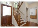 Inviting home foyer featuring hardwood floors, wood stairs, a wood front door and views into other rooms at 1402 Princess Anne Rd, Cary, NC 27513