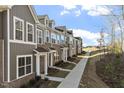 Row of townhomes with brick accents and vertical siding, set along a landscaped walkway at 231 Frosted Iris Lane Ln # 174, Garner, NC 27529