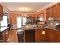 A well-lit kitchen showcases wooden cabinets, granite countertops, and access to the backyard at 2701 Erinridge Road Rd, Raleigh, NC 27610