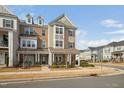 Attractive multi-story townhouse featuring a combination of brick and siding exterior, dormer windows, and landscaping at 2959 Sunflower Rd, Apex, NC 27502