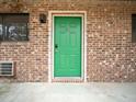 Close-up of a vibrant green apartment door with brick facade at 3 Shepherd Ln # Bldg C, Chapel Hill, NC 27514
