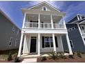 Two-story home showcasing a double porch with white columns, dark shutters, and manicured landscaping at 308 White Oak Garden Way # 215, Garner, NC 27529
