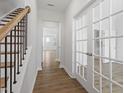 Inviting foyer with hardwood floors, staircase, and elegant French doors leading to a home office at 308 White Oak Garden Way # 215, Garner, NC 27529