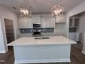 Modern kitchen features a large island, stainless appliances, and stylish pendant lighting at 308 White Oak Garden Way # 215, Garner, NC 27529